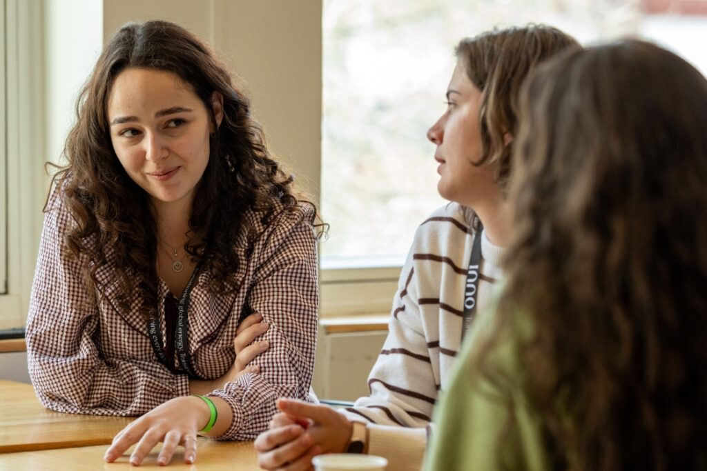Three students talking together during a Masters+ activity