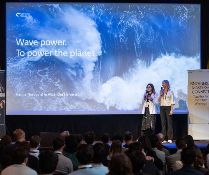 Two speakers presenting on stage at a Masters+ event