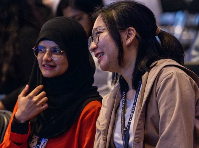 Two students talking together at a Masters+ event