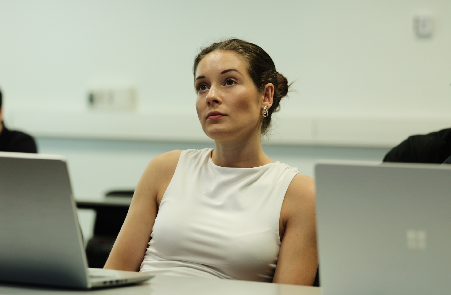 Student attending a university class with a laptop