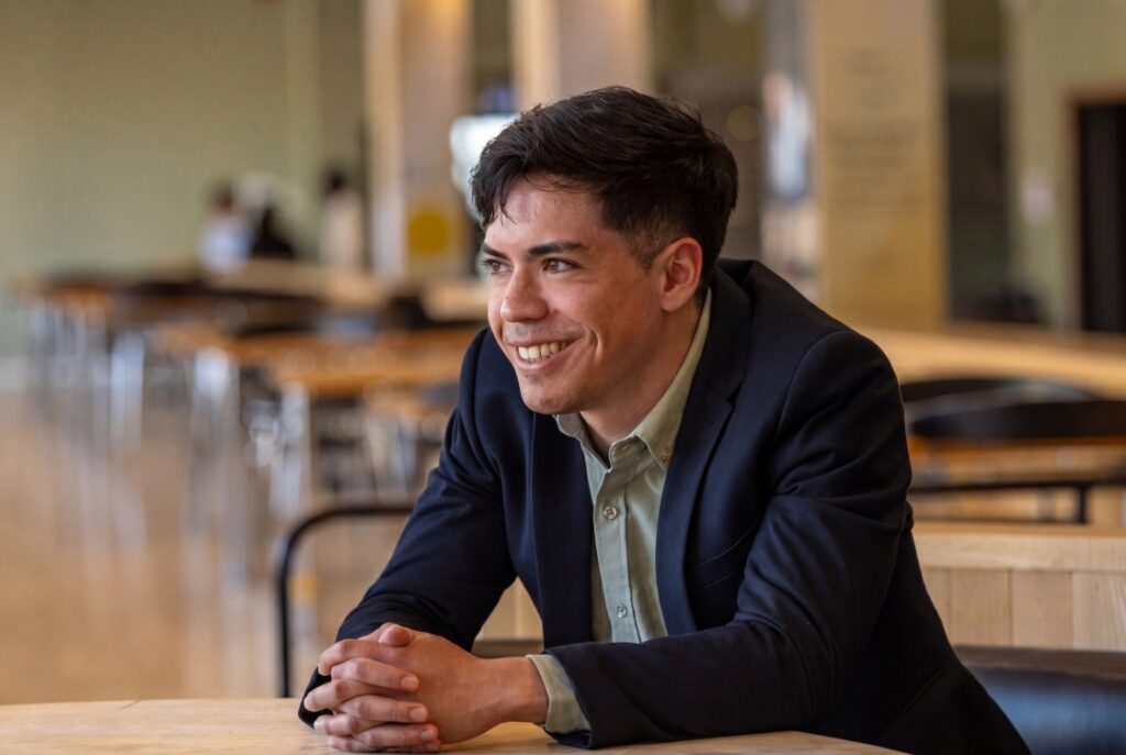 Student seated at a table in a university setting