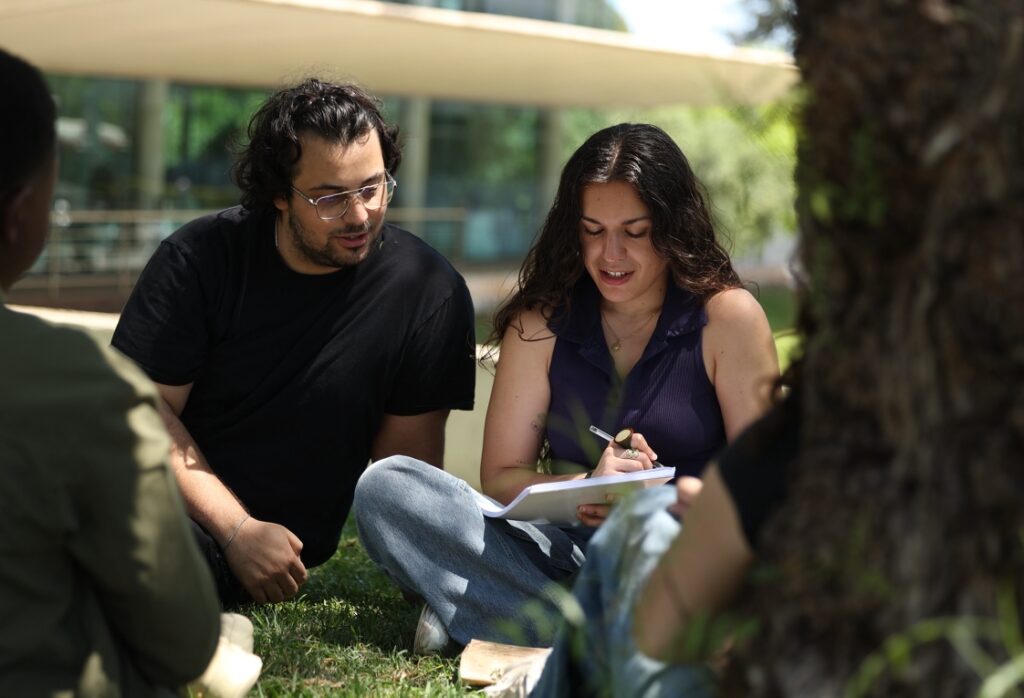 Masters+ students working together outdoors during a group activity