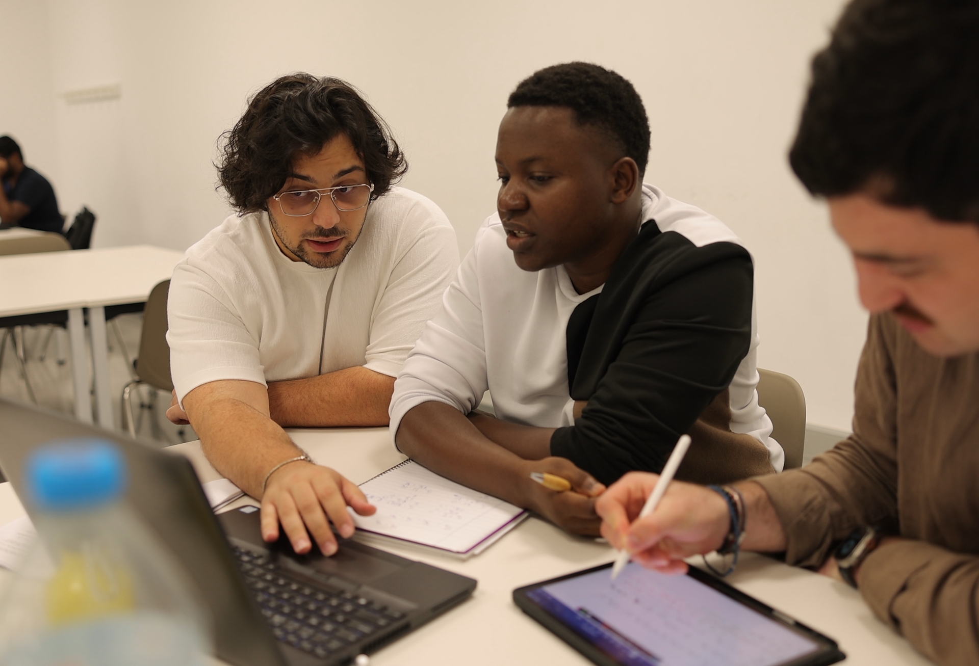 Masters+ students working together on a project with a laptop and tablet