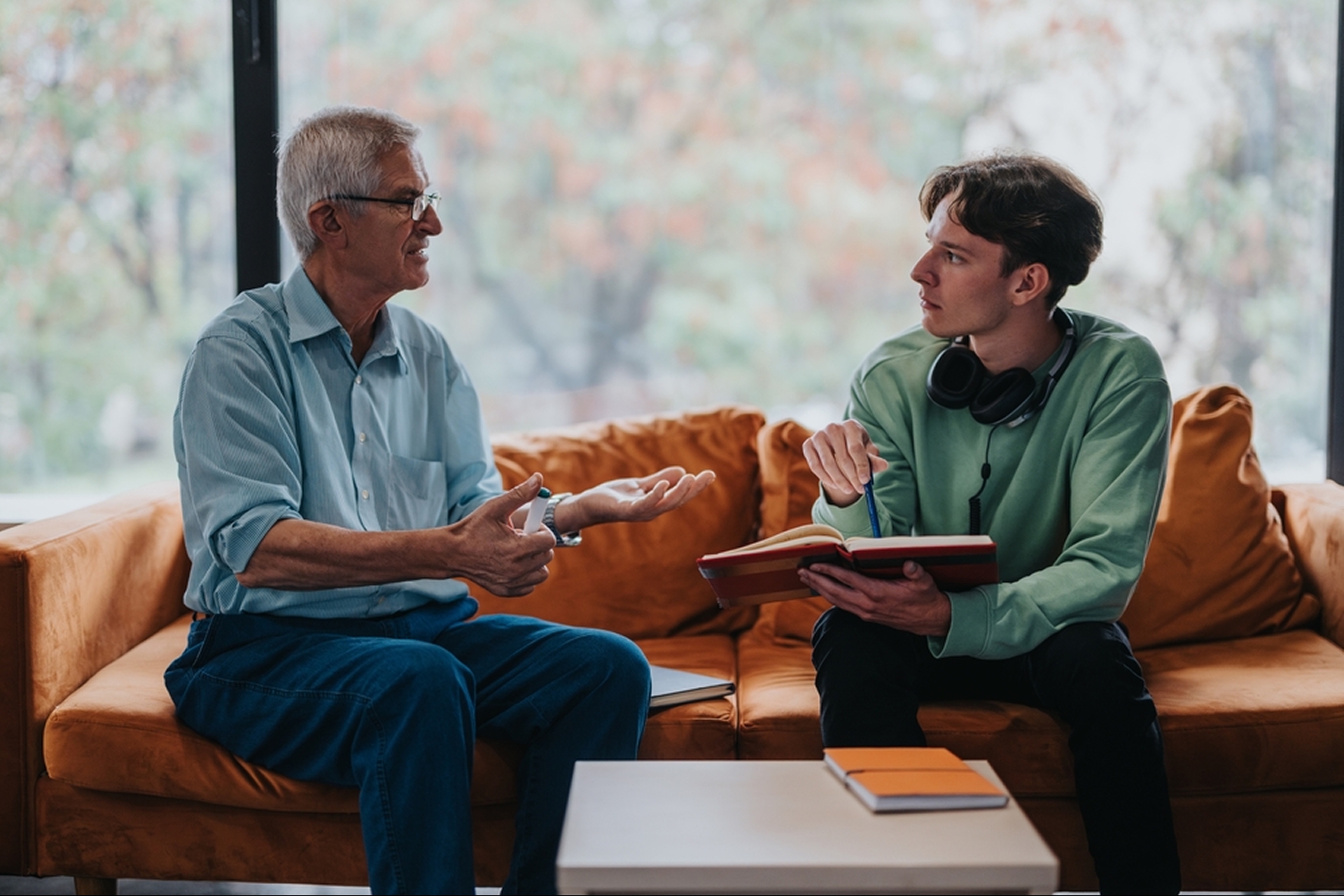 Student taking notes while speaking with a mentor